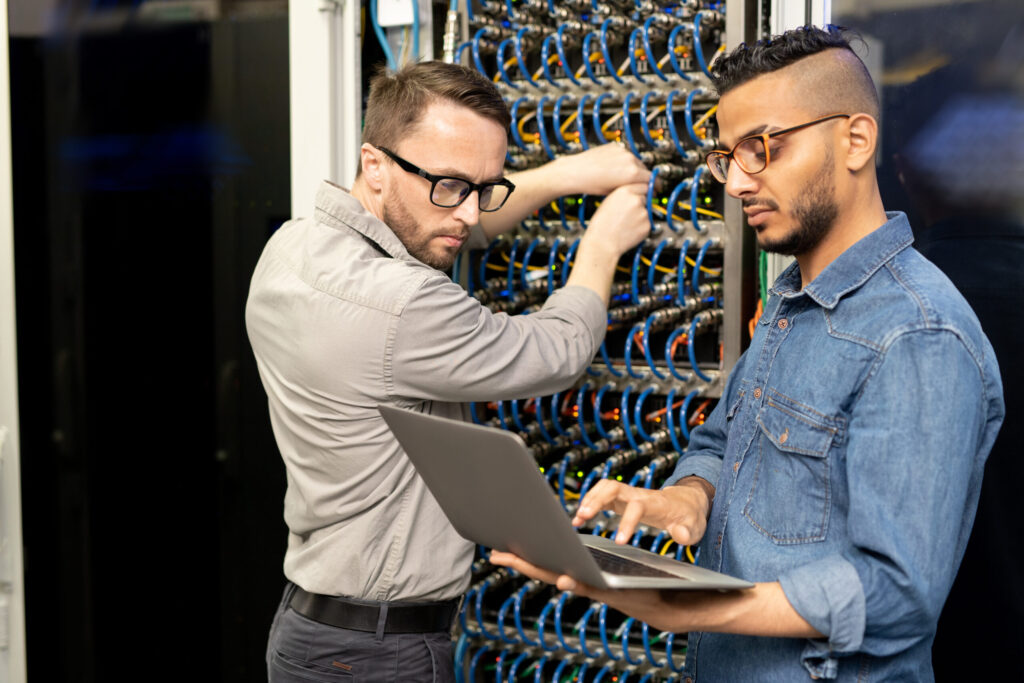 Multi Ethnic It Engineers Setting Up Computer Cluster