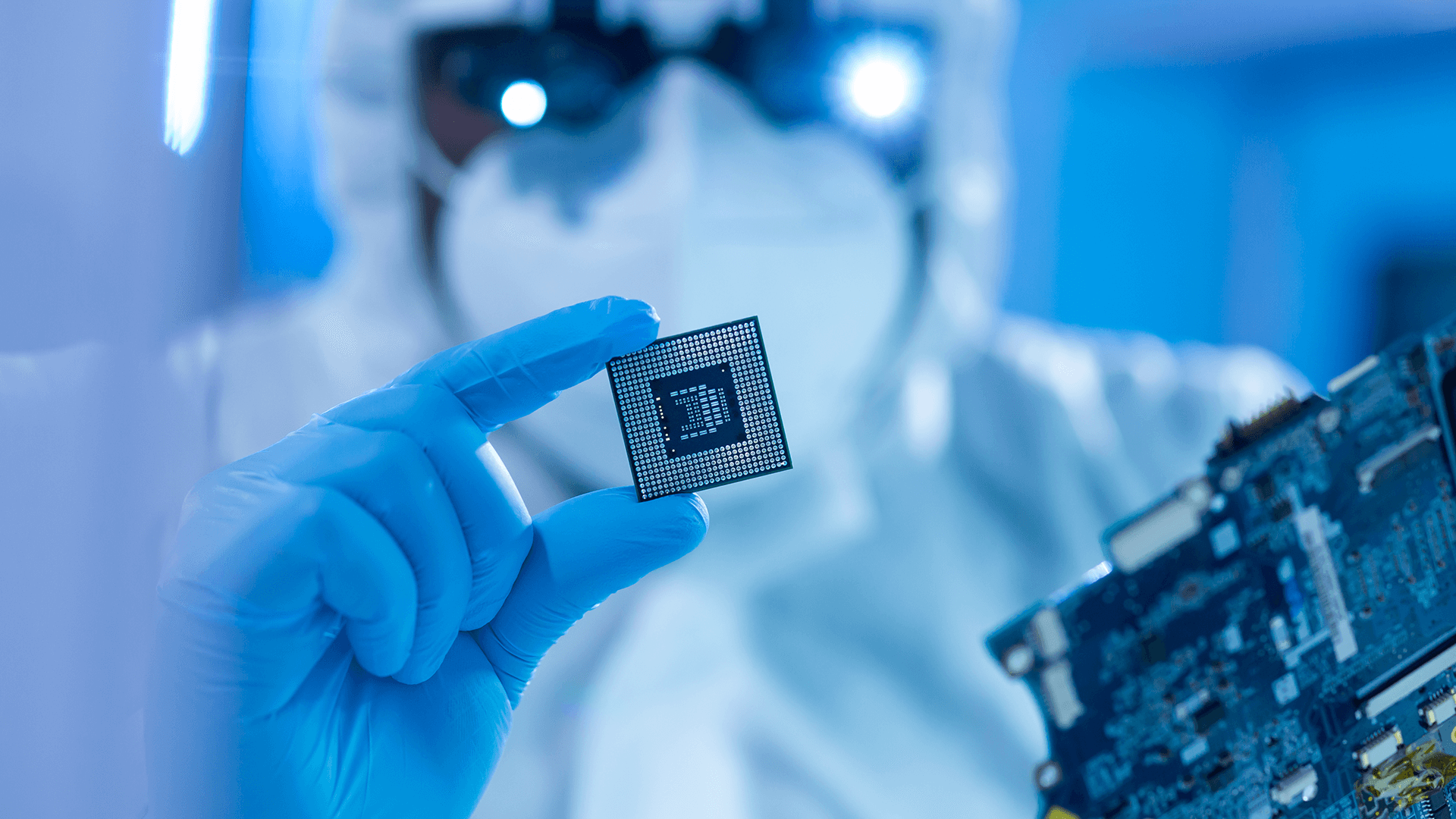 scientist in blue gloves inspecting a semiconductor in a laboratory