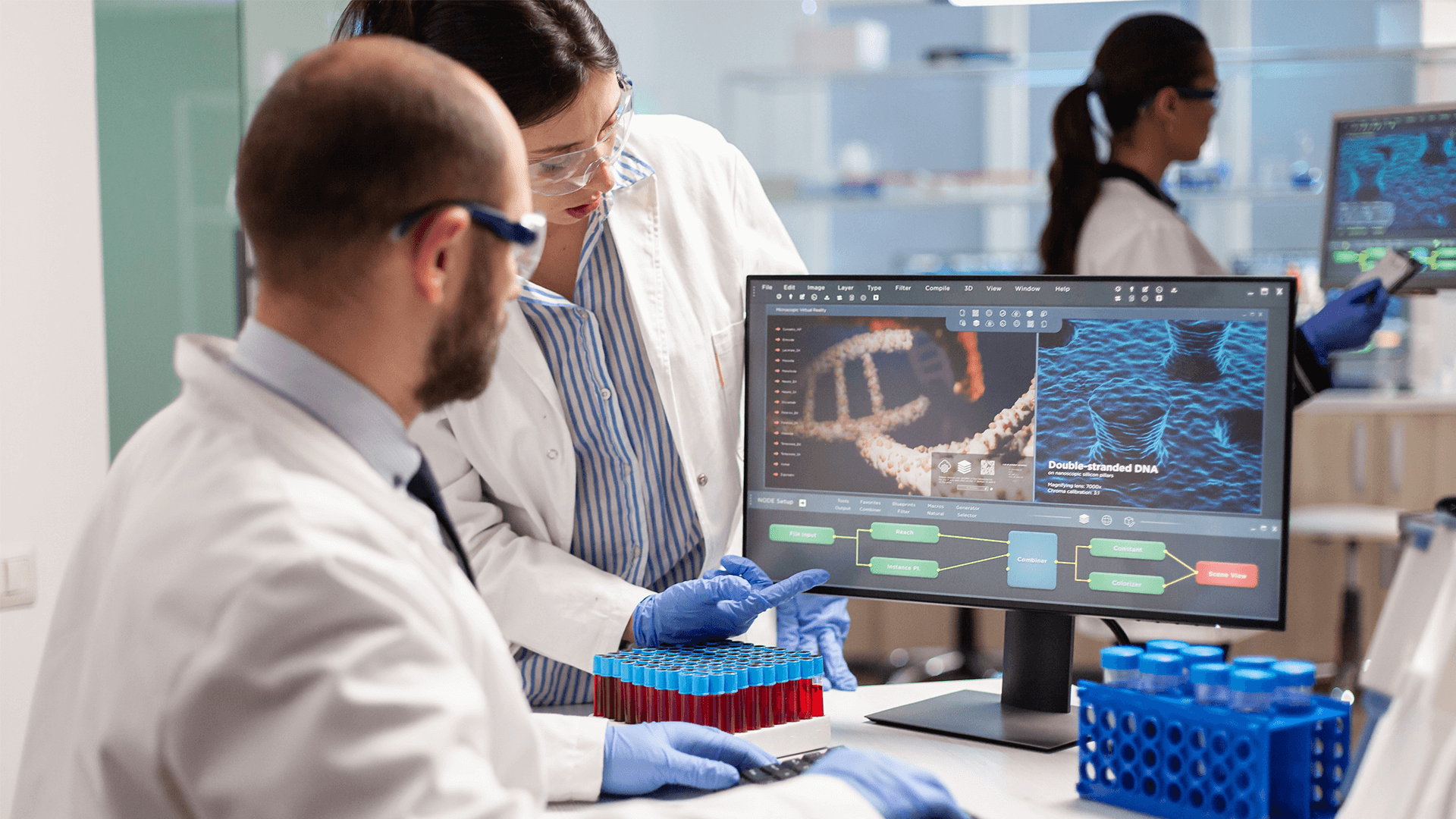 two scientists looking at DNA on a computer in a biotechnology company
